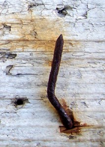 rusty nail on driftwood
